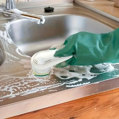 Person cleaning a kitchen counter with a scrubber and wearing a green glove.